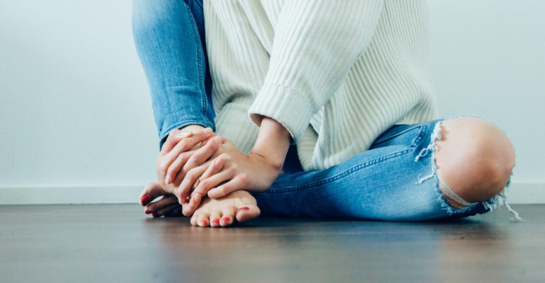 person wearing distressed blue denim jeans inside room