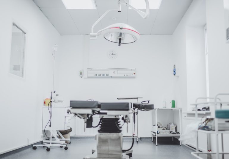 black and white hospital bed in the middle of interior building