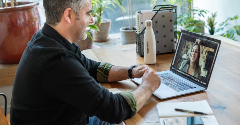 man in black sweater using macbook pro